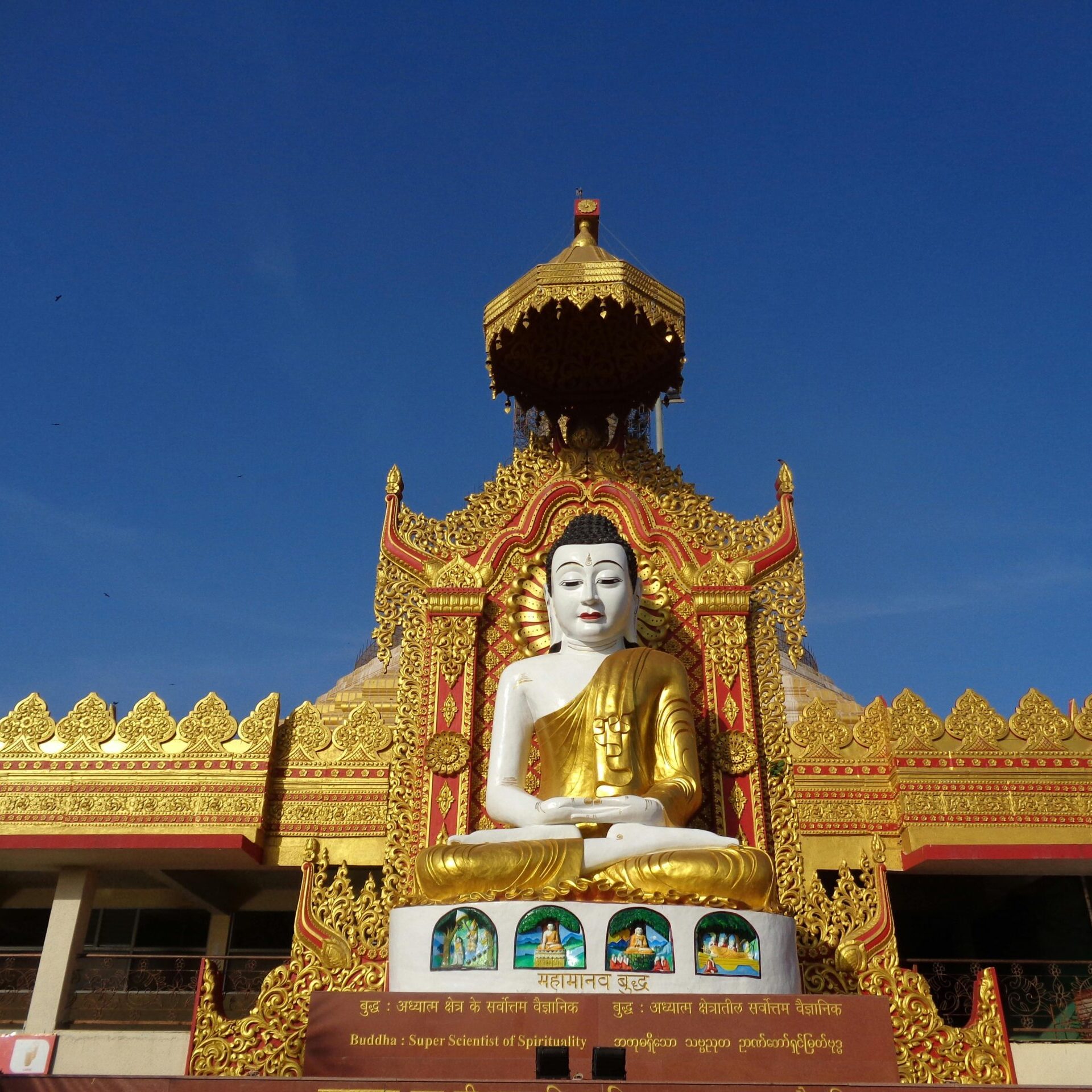 Magnificent golden Buddha statue at a decorated temple entrance in full daylight